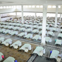photo of room with many hospital beds lined up in rows